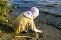 Little girl playing with sand on river beach Royalty Free Stock Photo
