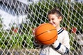 Close up of a little girl smiling with a basketball, vertical photo Royalty Free Stock Photo