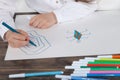 Close up of little girl in white blouse which is focused on drawing. Preschooler is learning how to draw. Kindergarten and school.