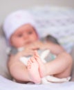 Close up of little 6 months old sweet baby girl in electric swing or cradle outdoors on sunny summer day. Close up of small feet Royalty Free Stock Photo