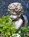 Cemetery scene. Close up of a sad pensive angel sitting on a grave. Pain, fear, end of life Royalty Free Stock Photo