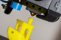 Close-up of little plastic ABS ship model. Yellow filament. Modern 3D printer printerhead with hotend and fan. Royalty Free Stock Photo