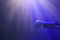 Microphone on stage against spotlights Royalty Free Stock Photo