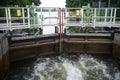 Close up from a lock filling up with water from upstream. A device used for raising and lowering boats, ships and other watercraft Royalty Free Stock Photo