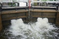 Close up from a lock filling up with water from upstream. A device used for raising and lowering boats, ships and other watercraft Royalty Free Stock Photo