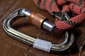 Close up of locking carabiner with the gate open and a knotted loop of rope hooked through the nose of the carabiner