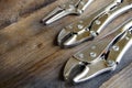 Close up locking pliers on wooden background, Hand tools in work shop