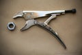 Close up locking pliers on wooden background, Hand tools in work shop