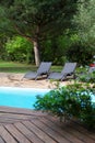 Close-up of long chairs by swimming pool