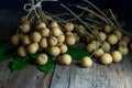 Close up of longan fruit with leaves is placed on a rustic wooden floor Royalty Free Stock Photo