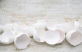 Close up of lots of broken white eggshells on an aged wood background