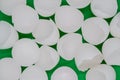 Close up of lots of broken white eggshells on a green background