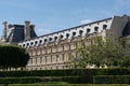 Close-up of Louvre palace with park, Pavillon de Marsan, lawn and flowers at hot sunny day. Paris - France, 31. may 2019 Royalty Free Stock Photo