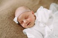 Close-up lovely newborn baby girl on a blanket. A portrait of a beautiful  newborn baby girl wearing a headband. Closeup photo Royalty Free Stock Photo