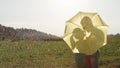 CLOSE UP: Lovely young couple kiss in rain while hiding behind a yellow umbrella Royalty Free Stock Photo