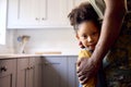 Close Up Of Loving Army Father In Uniform Home On Leave Hugging Daughter In Family Kitchen