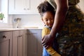 Close Up Of Loving Army Father In Uniform Home On Leave Hugging Daughter In Family Kitchen