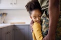 Close Up Of Loving Army Father In Uniform Home On Leave Hugging Daughter In Family Kitchen