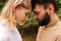 Close-up of loving married couple standing foreheads touched with closed eyes. Happy young bearded man and pretty blonde Royalty Free Stock Photo