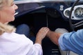 Close Up Of Loving Mature Couple Holding Hands On Road Trip In Classic Open Top Sports Car