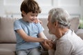 Close up loving mature grandfather calming little boy, holding hands