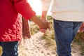 Close Up Of Loving Senior Couple Holding Hands Walking Through Sand Dunes On Winter Vacation Royalty Free Stock Photo