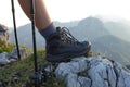 CLOSE UP: Active girl in hiking boots rests at the summit to watch the sunrise. Royalty Free Stock Photo