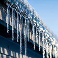 Sparkling Icicles Hanging from Eaves Against Blue Sky Royalty Free Stock Photo