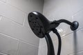 Close up, low angle view of a modern black detachable shower head in a white tiled bathtub Royalty Free Stock Photo