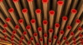 Abstract pattern of metallic organ pipes with red caps viewed from below image photo Royalty Free Stock Photo