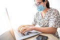 oman in quarantine for Coronavirus wearing protective mask and Hands holding credit card and using laptop. Online shopping Royalty Free Stock Photo