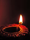 Close up low key diwali oil clay lamp,chirag or panti on a dark orange black background with bright orange red light illu Royalty Free Stock Photo