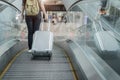 Close up lower body of woman traveler with luggage suitcase going to around the world by plane. Female tourist on automatic Royalty Free Stock Photo