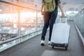 Close up lower body of woman traveler with luggage suitcase going to around the world by plane. Female tourist on automatic escala Royalty Free Stock Photo