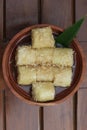 a close up of lupis with grated coconut and brown sugar sauce