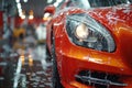 Close-up of luxurious red car getting washed at an automatic car wash, with the headlights in focus Royalty Free Stock Photo