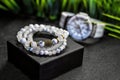 Close-up of luxurious white bracelets made of natural stones and pearls, on a background of watches Royalty Free Stock Photo