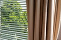 Close up of luxury brown curtains with venetian blinds in bedroom on the morning