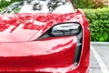 Close-up luxury shiny red sportscar supercar vehicle LED headlight lamp detail parked on city street outdoors. Electric car front Royalty Free Stock Photo