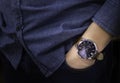 Close-up of luxury watch brown leather strap on wrist of man. Business man hand in pants pocket. Royalty Free Stock Photo
