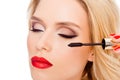 Close up of luxury woman with red lips doing make up with brush of mascara Royalty Free Stock Photo