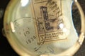 Close up of machine cancelled postage stamp through marine magnifying glass Royalty Free Stock Photo