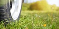 Close-up machine wheel on nature outdoors. Car is parked on grass, sunny summer day. Camping trip, vacation, travel concept. Royalty Free Stock Photo