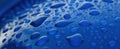 Close up macro of blue water droplets on a reflective surface Royalty Free Stock Photo