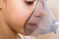 Close up, macro. The child`s face in the process of inhalation with a nebulizer. Therapy of coronavirus, broncho tracheitis Royalty Free Stock Photo