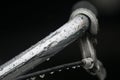 Close up / Macro image of bicycle handlebar in the rain with lots of water droplets on the steel. Royalty Free Stock Photo
