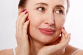 Close-up and macro portrait of beautiful and healthy middle aged woman face on white background. Wrinkles and menopause.