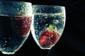 Close up, macro. Red strawberry floating in a alcoholic drink with bubbles. Isolated on black background Royalty Free Stock Photo