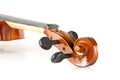 Close up macro of scroll on brown wooden fiddle or violin, classic musical instrument, over white background