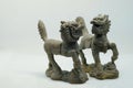 Close-up macro shot of a pair of bronze Chinese Qilin figurines, on white background